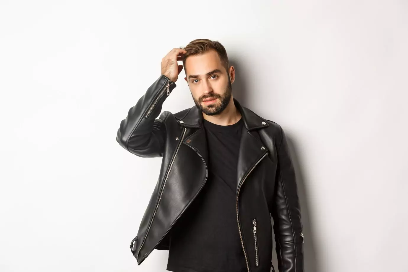 handsome-macho-man-black-biker-jacket-touching-his-haircut-looking-cool-